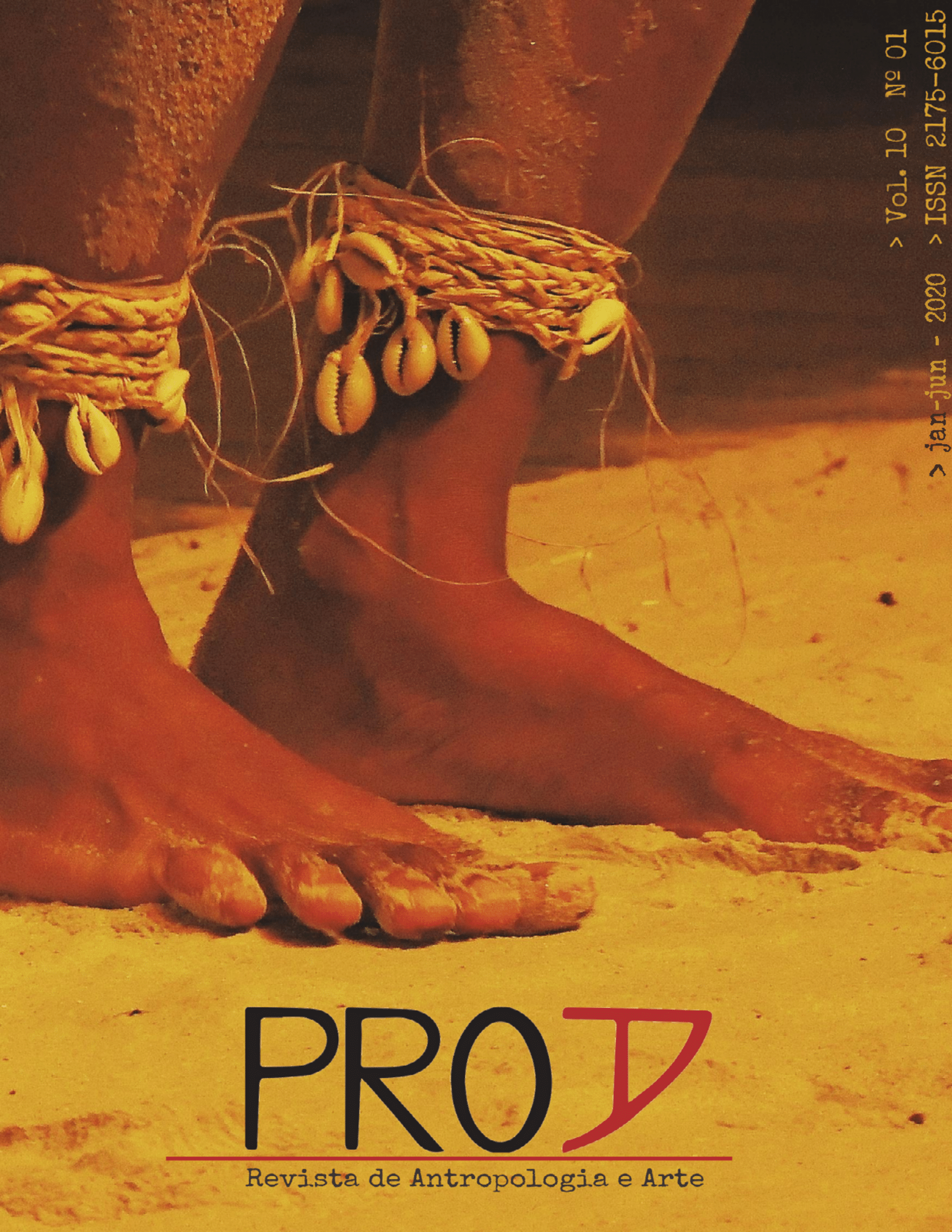 Uma foto de pés descalços com adornos de conchas nos tornozelos em meio a areia, com a marca da revista exibida na parte inferior central da imagem.